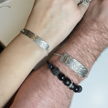 Load image into Gallery viewer, Two wrists wearing silver bracelets with a beaded black bracelet on one wrist.