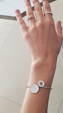 Load image into Gallery viewer, Hand wearing a silver ring and bracelet on a light background
